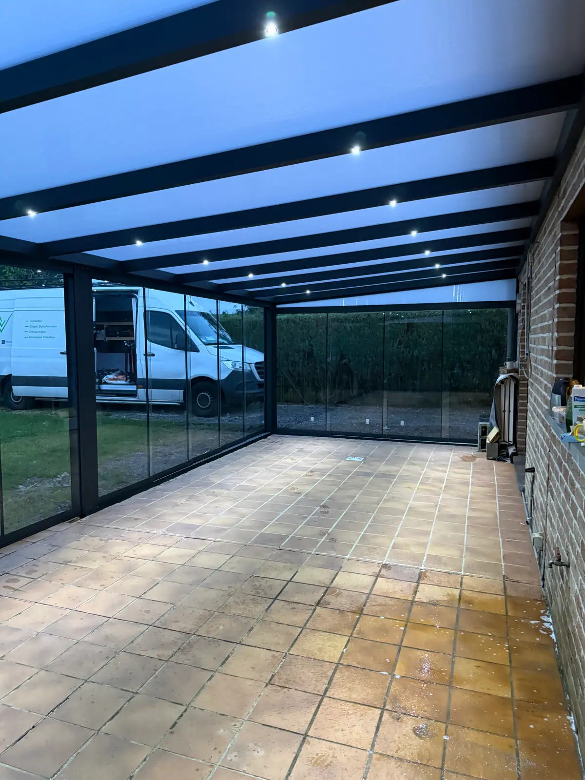 The same veranda later that evening, seen from inside, with the built-in lighting on